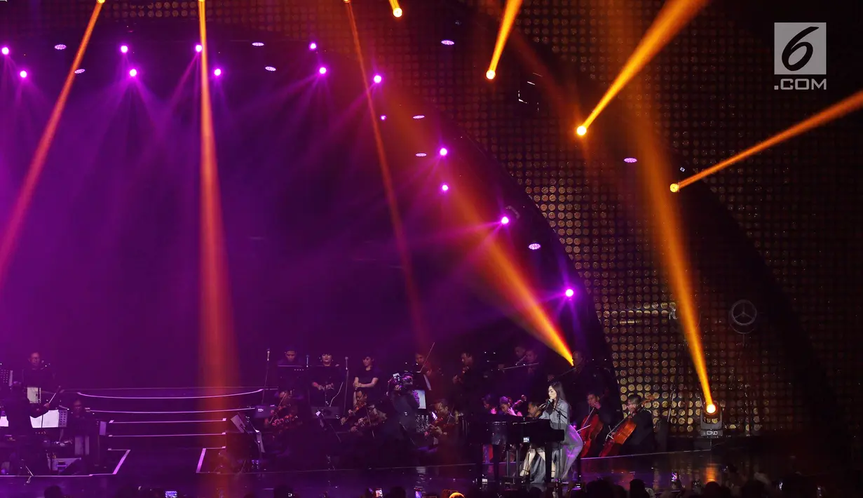Aksi penyanyi Isyana Sarasvati memainkan piano saat tampil pada konser Colours of Love di Jakarta, Rabu (20/12). Konser Ayat-ayat Cinta 2 dibuka dengan penampilan solo Isyana Sarasvati. (Liputan6.com./Herman Zakharia)
