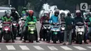 Pengendara motor di pemberhentian lampu Merah, Kota Depok, Jawa Barat, Minggu (12/4/2020). Menteri Kesehatan menyetujui menerapkan Pembatasan Sosial Berskala Besar (PSBB) di wilayah Kota Depok yang akan dimulai, Rabu (15/4) dalam pencegahan meluasnya COVID-19. (Liputan6.com/Helmi Fithriansyah)