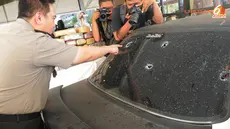 Kapolres Jakarta Utara tengah menunjukkan lubang pada kaca mobil yang ditembak petugas untuk melumpuhkan pelaku (Liputan6.com/ Herman Zakharia)