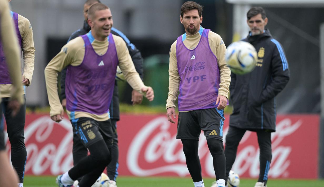 Penyerang Argentina, Lionel Messi (kanan) mengamati bola di samping gelandang Franco Mastantuono selama sesi latihan di Ezeiza, Provinsi Buenos Aires, Argentina, pada 2 September 2025. (JUAN MABROMATA/AFP)
