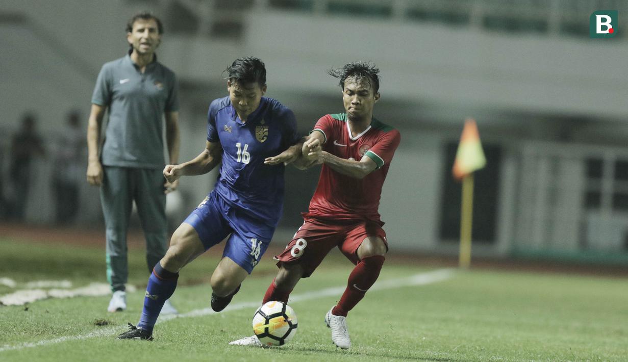 Gelandang Indonesia, Muhammad Hargianto, berebut bola dengan pemain Thailand, Phitiwat Sookjitthammakul, pada laga persahabatan di Stadion Pakansari, Bogor, (03/6/2018). Indonesia bermain imbang 0-0 dengan Thailand. (Bola.com/M Iqbal Ichsan)