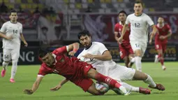 Dendy Sulistyawan dijatuhkan ketika membela Timnas Indonesia melawan Timnas Turkmenistan di Stadion Gelora Bung Tomo (GBT), Surabaya, pada Jumat (8/9/2023). (Bola.com/Aditya Wany).