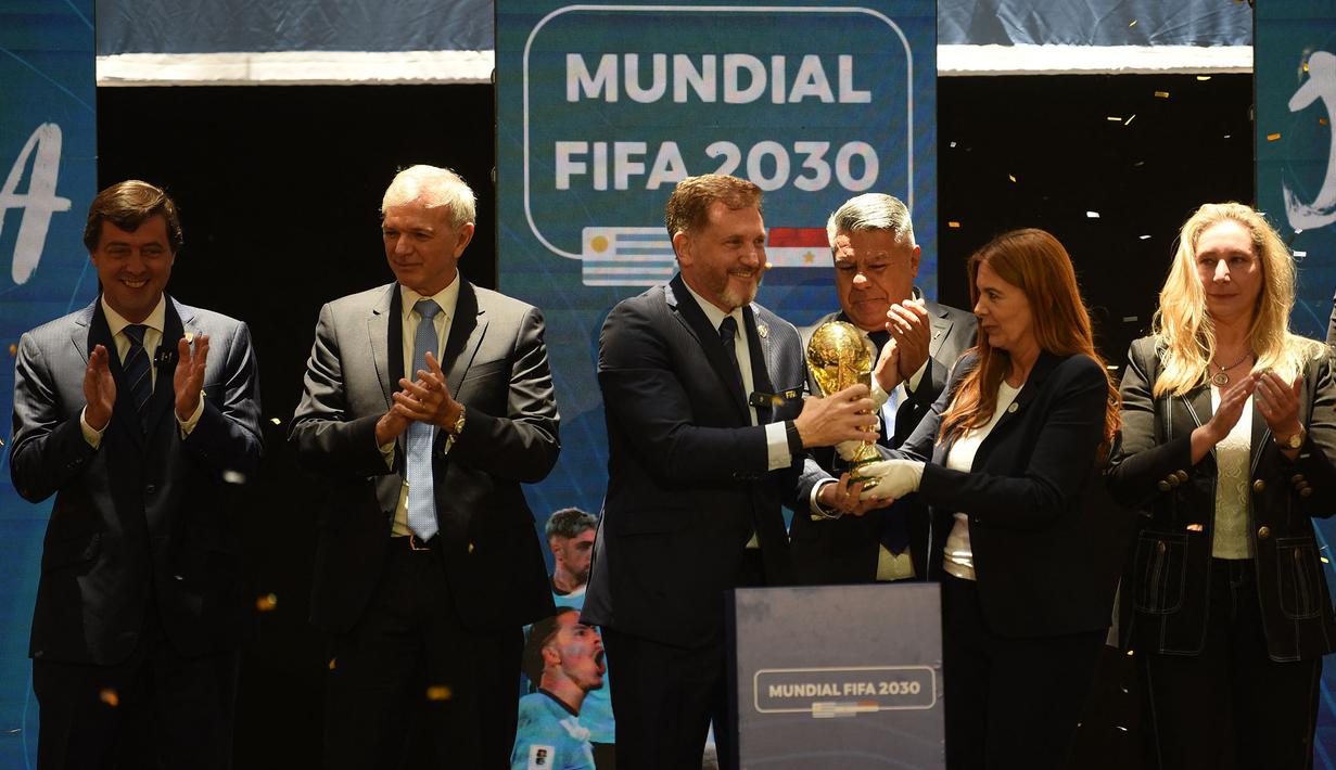 Presiden Paraguay, Alejandro Dominguez (tengah) memegang replika trofi Piala Dunia saat penunjukkan Argentina, Paraguay, dan Uruguay sebagai negara tuan rumah Piala Dunia FIFA 2030 selama Kongres virtual FIFA di Luque, Paraguay pada 11 Desember 2024. (AFP/Daniel Duarte)