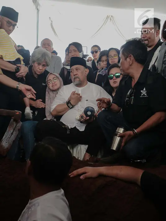 Komedian Indro Warkop menenangkan anaknya saat pemakaman istrinya, Nita Octobijanthy di TPU Tanah Kusir, Jakarta, Rabu (10/10). Nita meninggalkan tiga orang anak. (Liputan6.com/Faizal Fanani)