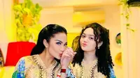 Krisdayanti dan Amora kompak mengenakan kaftan warna dasar gold dengan corak bunga warna-warni. [@krisdayantilemos]