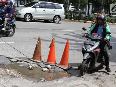 Pengendara menghindari jalan berlubang di kawasan Tanjung Barat, Jakarta, Rabu (30/1). Musim penghujan, pengguna jalan mengeluhkan jalan berlubang yang dipenuhi air.  (Liputan6.com/Immanuel Antonius)