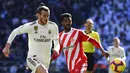 Gelandang Real Madrid, Gareth Bale, berebut bola dengan bek Girona, Jonas Ramalho, pada laga La Liga di Stadion Santiago Bernabeu, Madrid, Minggu (17/2). Madrid kalah 1-2 dari Girona. (AFP/Gabriel Bouys)