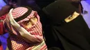 <p>Seorang pria Saudi menggunakan keffiyeh tradisionalnya sebagai masker ketika ia menyaksikan pertandingan gulat WWE Super ShowDown di Riyadh, Arab Saudi, Kamis (27/2/2020). Arab Saudi menghentikan sementara izin umrah karena kekhawatiran tentang epidemi virus corona COVID-19. (AP Photo/Amr Nabil)</p>