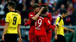 Thomas Mueller, Mario Goetze and David Alaba merayakan gol saat berjumpa Borussia Dortmund  dalam lanjutan Bundesliga di Stadion Allianz Arena, Muenchen, Minggu (4/10/2015). Muenchen menang telak 5-1 atas Dortmund.(REUTERS/Michael Dalder)