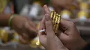 <p>Seorang pelanggan mencoba gelang emas selama festival Hindu 'Akshaya Tritiya', hari keberuntungan dalam kalender Hindu untuk membeli barang-barang berharga, di ruang pamer perhiasan di Chennai, India, Selasa (3/5/2022). Membeli emas adalah kegiatan yang populer di Akshaya Tritiya, karena ini adalah simbol utama kekayaan dan kemakmuran. (Arun SANKAR / AFP)</p>