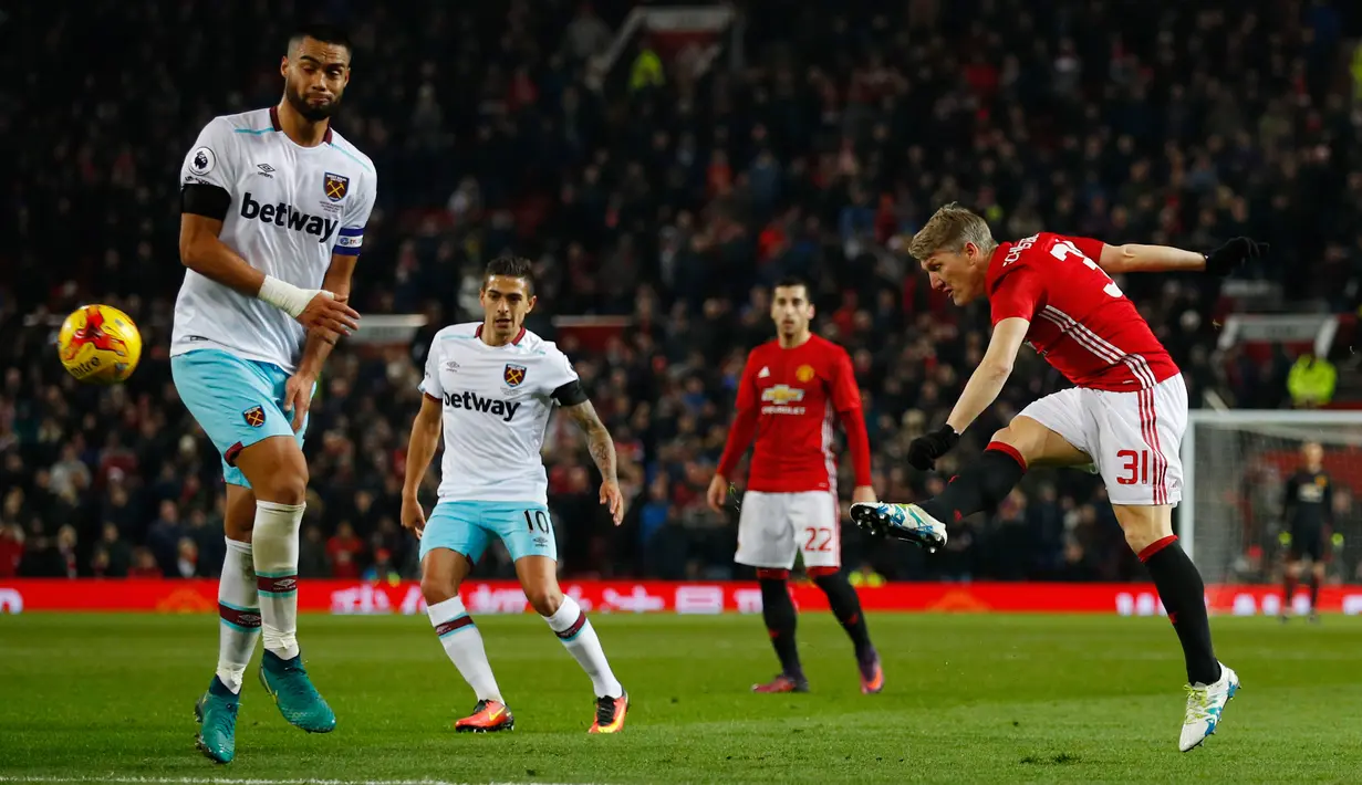 Aksi Gelandang MU, Bastian Schweinsteiger menendang bola dari kawalan bek West Ham United, Winston Reid di perempat final Piala Liga (EFL Cup) di Stadion Old Trafford, Inggris, (1/12). MU menang telak atas West Ham dengan skor 4-1. (Reuters/Phil Noble)