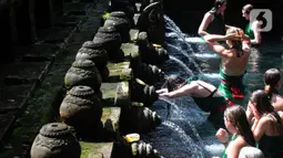 Wisatawan antri membersihkan diri (melukat) di Pura Tirta Empul, Desa Tampaksiring, Gianyar, Bali, jumat (6/5/20222). Dalam sehari, lebih dari 2.000 wisatawan berkunjung ke obyek wisata spiritual i yang menjadi salah satu primadona di Pulau Bali ini. (merdeka.com/Arie Basuki)