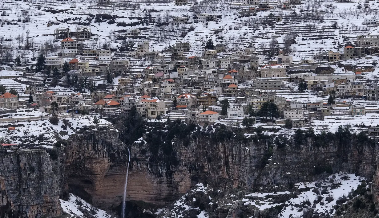 Kota Bcharre yang tertutup salju, menghadap ke lembah Qadisha di gunung Lebanon, di utara ibu kota Beirut (22/2/2022).(AFP/Ibrahim Calhoub)