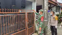 Babinsa didampingi Bhabinkamtibmas menyalurkan paket obat untuk warga isolasi mandiri di Kelurahan Mampang, Kecamatan Pancoran Mas, Kota Depok. (Liputan6.com/Dicky Agung Prihanto)