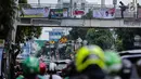 Warga melintasi jembatan penyeberangan orang (JPO) yang terdapat alat peraga kampanye (APK) di Mampang, Jakarta, Rabu (27/2). APK masih menghiasi JPO meski KPU telah melarang pemasangan di sarana dan prasarana publik. (Liputan6.com/Faizal Fanani)