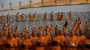 Sejumlah biksu berbaris untuk menerima sedekah usai melakukan ritual Makha Bucha Day di kuil Wat Dhammakaya, Bangkok, Thailand (11/2). (AFP/Lillian Suwanrumpha)