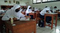 Pelajar SMP Negeri 1 Tambun Selatan, Bekasi mengikuti Pembelajaran Tatap Muka (PTM) terbatas dengan kapasitas 50 persen. (Liputan6.com/Bam Sinulingga)