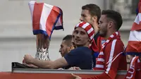 Striker Atletico Madrid, Antoine Griezmann, mengikuti konvoi perayaan gelar Liga Europa di Madrid, Jumat (18/5/2018). Kota Madrid menjadi merah saat perayaan gelar juara Atletico. (AFP/Oscar Del Pozo)