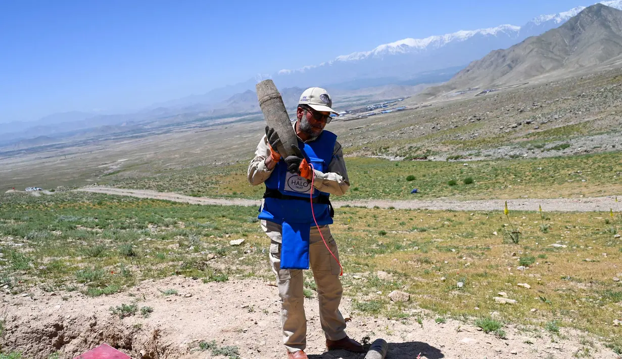 Seorang penjinak ranjau Afghanistan dari Halo Trust bersiap meledakkan ranjau yang belum meledak (UXO) di sebuah bukit di distrik Deh Sabz, Kabul pada tanggal 21 Mei 2024. (Wakil KOHSAR/AFP)