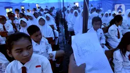 Murid-murid mengikuti kegiatan belajar di dalam tenda darurat di SDN Cirimekar 2, Cibinong, Bogor, Senin (6/1/2020). Hari ini merupakan hari pertama murid sekolah melakukan kegiatan belajar mengajar (KBM) paska libur tahun baru dan bencana banjir yang melanda kawasan Jabotabek. (merdeka.com/Arie Bas