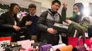 Pengunjung memilih tas yang dibanderol dengan diskon selama Boxing Day di pusat kota London, Senin (26/12). Boxing Day merupakan tradisi hari belanja terbesar tahunan yang diperingati setiap 26 Desember atau sehari setelah Natal. (DANIEL Leal-Olivas/AFP)