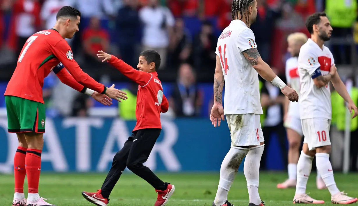 Beberapa penonton merangsek masuk lapangan untuk berfoto bersama pemain Portugal, Cristiano Ronaldo. (INA FASSBENDER/AFP)