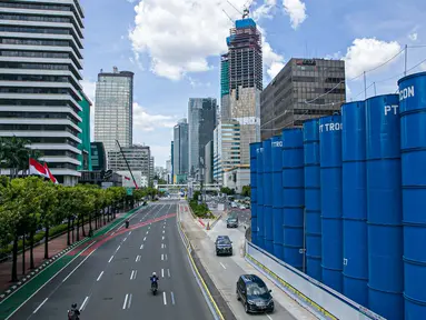 Sejumlah kendaraan melintas disamping proyek pembangunan MRT fase dua di Jalan MH Thamrin, Jakarta, Senin (22/3/2021). Dishub DKI Jakarta akan memberlakukan rekayasa lalu lintas di sekitaran pembangunan jalur MRT fase dua yang dimulai pada hari ini. (Liputan6.com/Faizal Fanani)