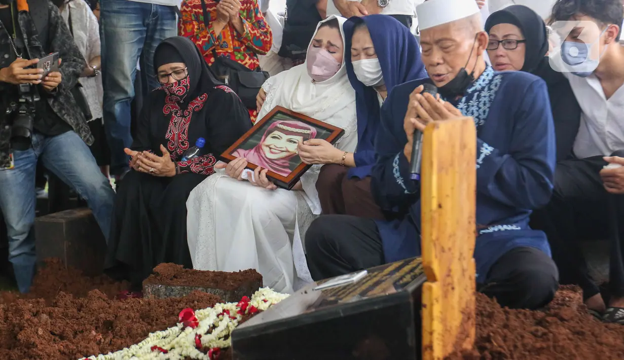 <p>Nia Zulkarnaen, putri aktris senior Mieke Wijaya, menangis sambil memegang foto sang ibunda saat prosesi pemakaman di TPU Tanah Kusir, Jakarta, Rabu (4/5/2022). Mieke Wijaya meninggal dunia pada Selasa, 3 Mei 2022 di Jakarta. Ia meninggal dunia pada usia 82 tahun. (Liputan6.com/Herman Zakharia)</p>