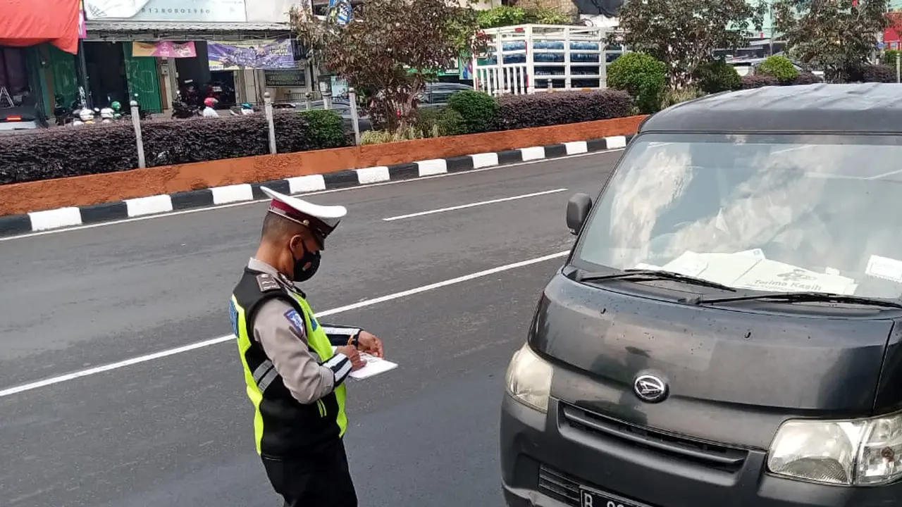 Anggota Satlantas Polres Metro Depok melakukan penilangan terhadap pengguna jalan di Jalan Raya Margonda, Kota Depok.