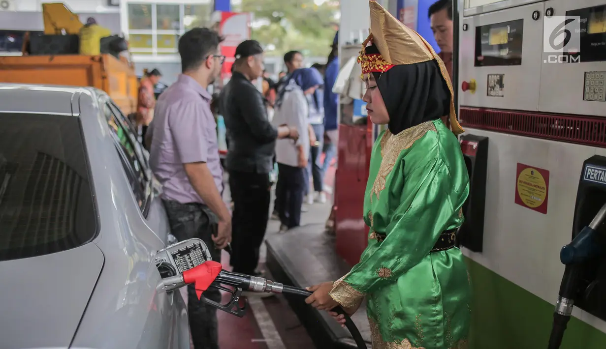 Petugas SPBU mengenakan pakaian adat mengisi bahan bakar minyak (BBM) ke sebuah mobil di kawasan Kelapa Gading, Jakarta, Senin (22/4). Dalam rangka memperingati Hari Kartini pengelola SPBU mengajak Seluruh pegawai SPBU mengenakan mengenakan baju kebaya dan baju adat. (Liputan6.com/Faizal Fanani)