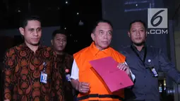 Gubernur Aceh, Irwandi Yusuf berjalan keluar mengenakan rompi oranye seusai pemeriksaan di gedung KPK, Jakarta, Kamis (5/7). KPK resmi menahan Irwandi Yusuf setelah ditetapkan sebagai tersangka kasus suap ijon proyek di Aceh. (Merdeka.com/Dwi Narwoko)