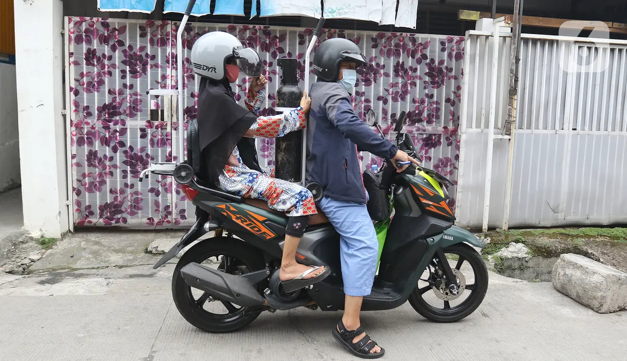 Warga membawa tabung oksigen di Fauzi Medical, Matraman, Jakarta Timur, Kamis (22/7/2021). Sebagai bentuk kepedulian terhadap sesama di tengah pandemi COVID-19, agen isi ulang oksigen tersebut menerapkan sistem pembayaran secara sukarela bagi warga. (Liputan6.com/Herman Zakharia)