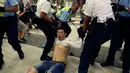 Polisi menyeret pengunjuk rasa yang menolak RUU Ekstradisi di luar gedung parlemen, Hong Kong, Senin (10/6/2019). Unjuk rasa ini disinyalir sebagai salah satu protes terbesar di Hong Kong sejak 2003 lalu terkait hukum keamanan nasional. (AP Photo/Vincent Yu)