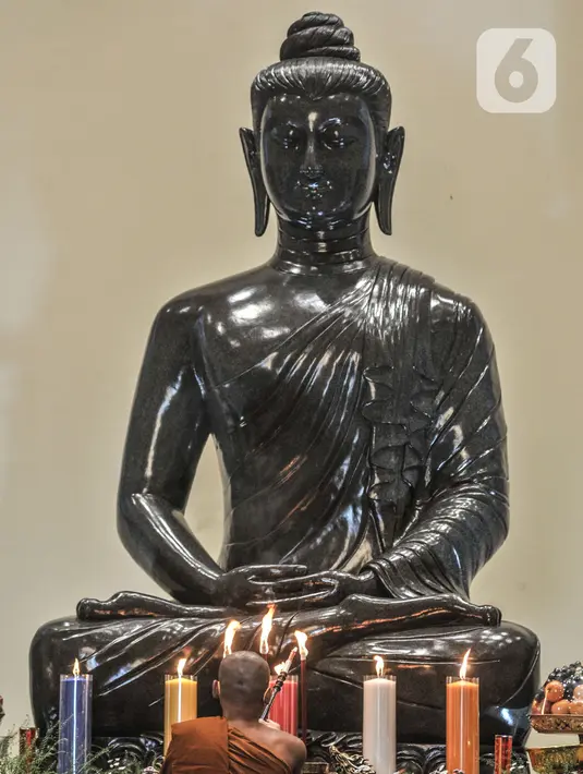 Biksu menyalakan lilin dan dupa saat peringatan Tri Suci Waisak 2565 BE di Vihara Hemadhiro Mettavati, Cengkareng, Jakarta Barat, Rabu (26/5/2021). (merdeka.com/Iqbal S. Nugroho)
