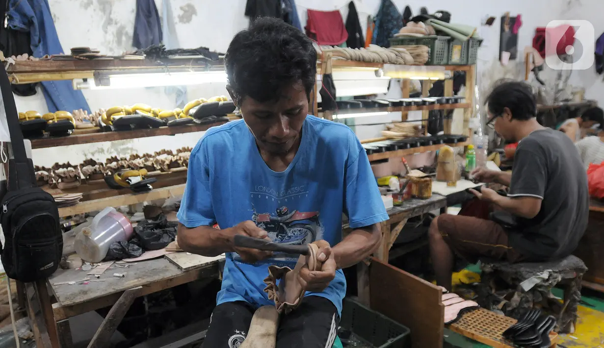 Perajin alas kaki menyelesaikan pembuatan sandal di kawasan Bojongsari, Depok, Jawa Barat, Selasa (22/2/2022). Sandal-sandal tersebut dijual ke Jakarta serta kota-kota di Pulau Sulawesi dan Pulau Bali. (merdeka.com/Arie Basuki)