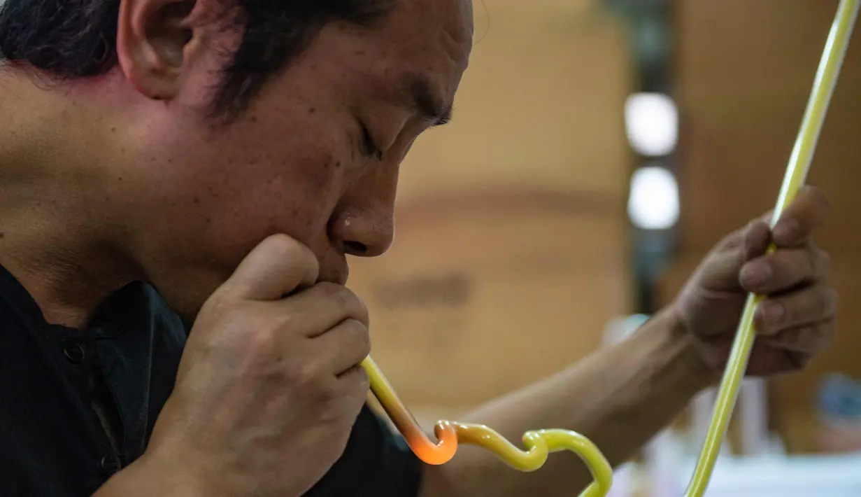 Wu Chi-kai mendemonstrasikan bagaimana membuat neon sign selama wawancara dengan AFP di Hong Kong (16/4). Kota Hong Kong  tidak pernah benar-benar kehilangan kegelapannya berkat cahaya 24 jam dari segudang neon sign. (AFP Photo/Philip Fong)