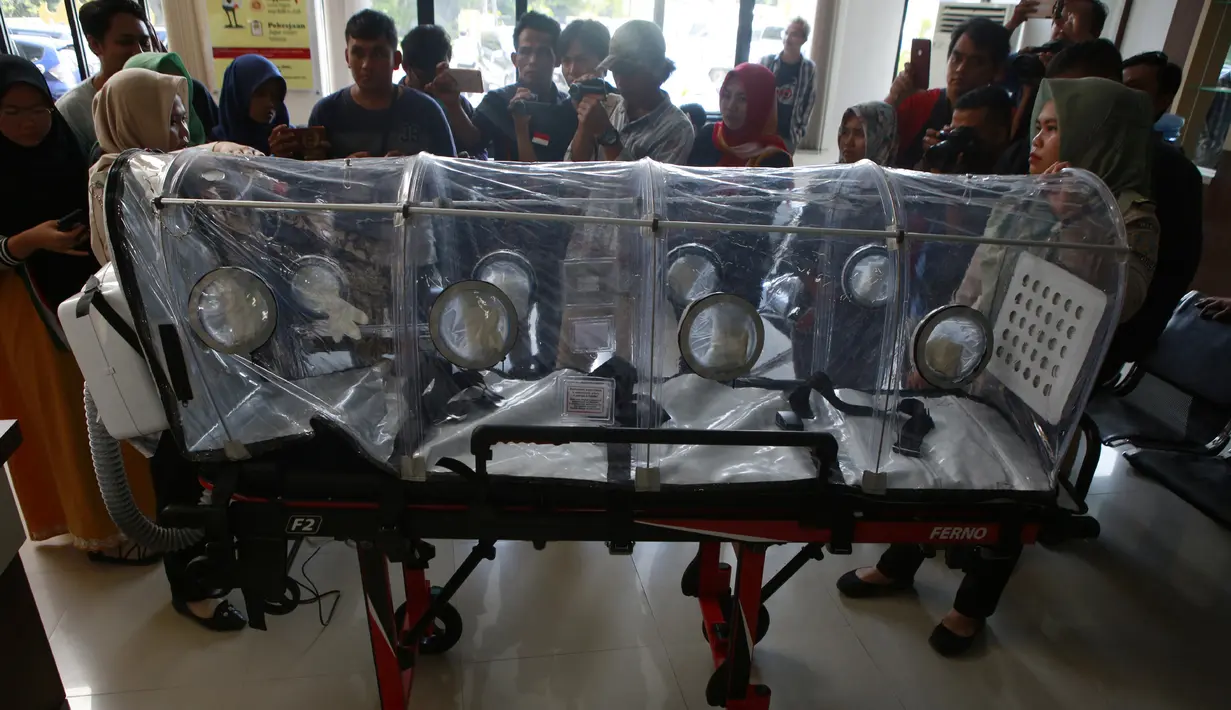 Petugas kesehatan Pelabuhan Kelas II Panjang menunjukkan tandu pelindung (isolation camber) di Lampung, Selasa (28/1/2020). Isolation camber ini menyerupai sebuah tandu yang dilengkapi dengan penutup sebagai ruang isolasi sementara untuk melindungi pasien terjangkit virus corona. (AFP/Perdiansyah)