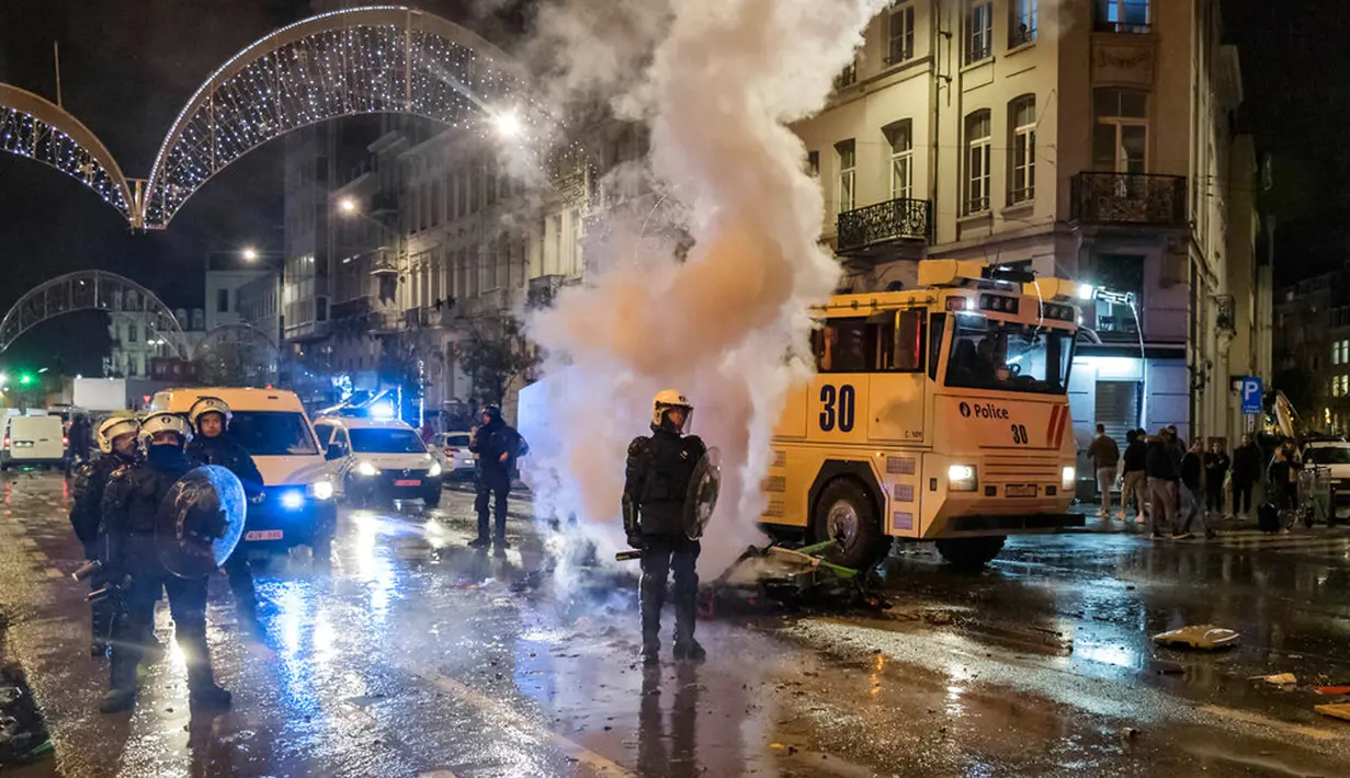 Polisi antihuru-hara berdiri di jalan utama di Brussel, Belgia, 27 November 2022. Polisi harus menutup sebagian pusat Kota Brussel dan bergerak dengan meriam air serta gas air mata untuk membubarkan massa menyusul kerusuhan selama dan setelah Maroko menang 2-0 atas Belgia di Piala Dunia 2022. (AP Photo/Geert Vanden Wijngaert)
