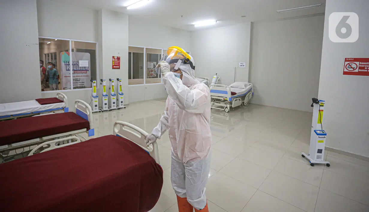 Petugas mengenakan hazmat saat menyiapkan tempat tidur di Tower 8 Wisma Atlet Pademangan, Jakarta, Selasa (15/6/2021). Koordinator Lapangan RSDC Wisma Atlet Letkol Marinir M. Arifin mengatakan soal alternatif Tower 8 Wisma Atlet Pademangan untuk pasien OTG COVID-19. (Liputan6.com/Faizal Fanani)