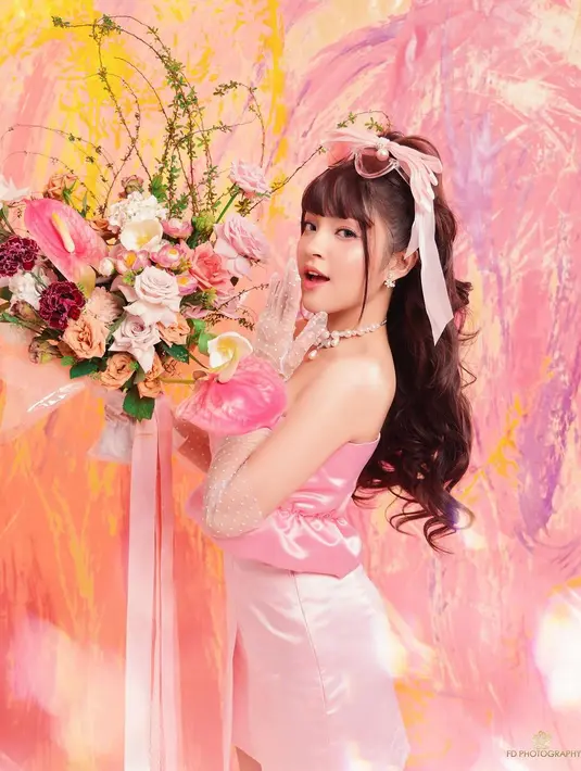 Eca Aura tampil bak Barbie di photoshoot ini. Rambut panjangnya yang diikal loose di-high ponytail dan diberi pemanis pita pink, diberi poni dan kacamata yang ditaruh di atas kepalanya. [Foto: Instagram/elsaajapasal]