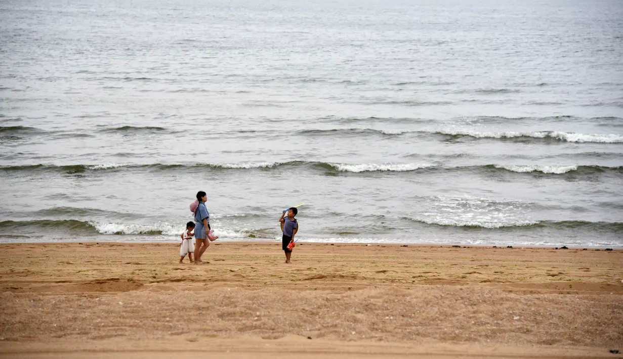 Orang-orang menikmati waktu bersantai di panttai di Rizhao, Provinsi Shandong, China timur (9/7/2020). (Xinhua/Wang Kai)