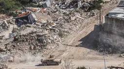 Foto menunjukkan sebuah kendaraan militer Israel melaju di antara rumah-rumah yang hancur di Lebanon Selatan, pada Senin 27 April 2026. (Jalaa MAREY/AFP)
