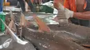 Pekerja memotong sirip hiu di tempat pelelangan ikan Karangsong, Indramayu, Jawa Barat, Kamis (16/6/2015). Meski sudah ada larangan perburuan dan perdagangan, nelayan setempat masih memperdagangkan sirip hiu. (Liputan6.com/Herman Zakharia)