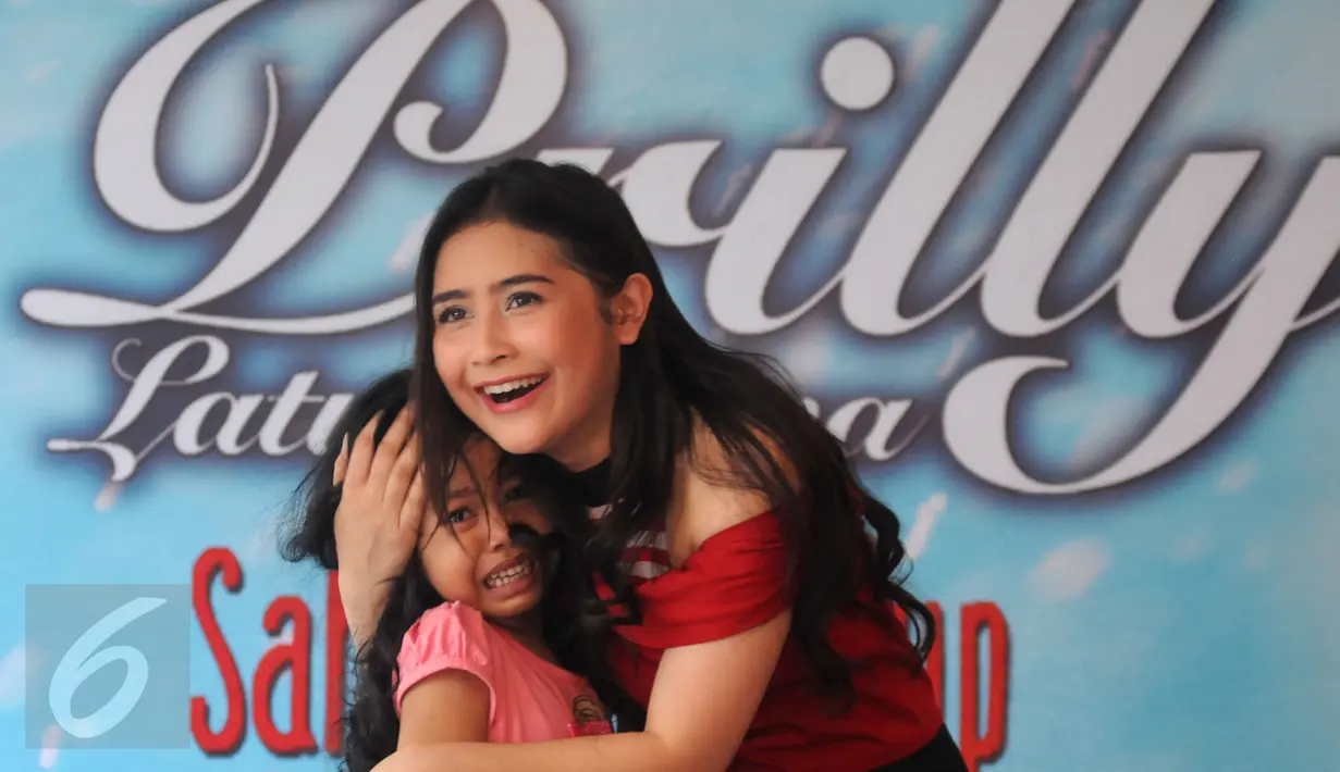 Prilly Latuconsina memeluk seorang penggemar saat perilisan album perdananya bertajuk Sahabat Hidup di  Lenteng Agung, Jakarta, Rabu (9/3). Album yang berisi sembilan lagu tersebut diproduseri oleh musisi Maia Estianty. (Liputan6.com/Herman Zakharia)