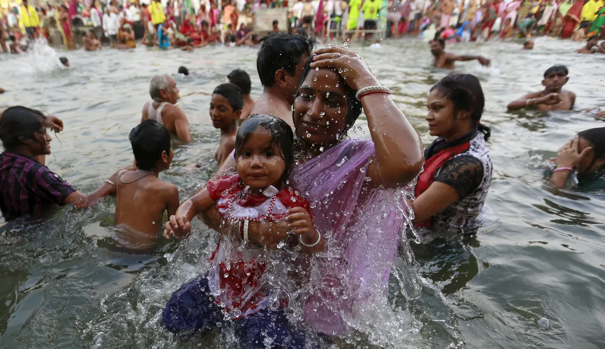 Seorang ibu dan anaknya berendam di Sungai Godavari saat Festival Pitcher di India, Jumat (28/8/2015). Ratusan ribu umat Hindu mengambil bagian dalam perayaan keagamaan yang diadakan setiap 12 tahun sekali di Sungai Godavari. (REUTERS/Danish Siddiqui)