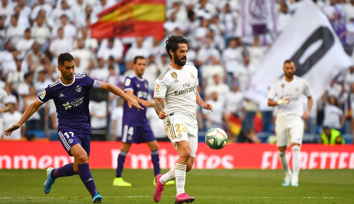 Gelandang Real Madrid, Isco, berusaha melewati bek Valladolid, Javi Moyano, pada laga La Liga di Stadion Santiago Bernabeu, Madrid, Sabtu (24/8). Kedua klub bermain imbang 1-1. (AFP/Gabriel Bouys)