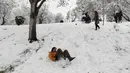 Seorang wanita meluncur di salju di sebuah taman di Teheran utara, Iran (19/1/2020). Salju tebal menutupi jalan-jalan Teheran, menyebabkan penundaan penerbangan dan munutup sekolah, kata pihak berwenang di ibukota Iran. (AP Photo / Vahid Salemi)