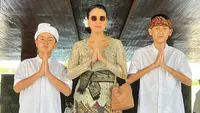 Kedua anak laki-lakinya memilih mengenakan kemeja putih lengan pendek dipadukan kain Bali yang serasi dengan ikat kepalanya. [@marcella.zalianty]