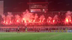 Suporter Madura United, menyalakan flare memperingati ulang tahunnya membuat laga melawan Persiba Balikpapan tertunda pada Torabika SC 2016 di Stadion Gelora Bangkalan, Senin(13/6/2016).  (Bola.com/Nicklas Hanoatubun)