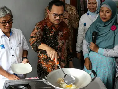 Menteri ESDM Sudirman Said mencoba memasak telur dengan menggunakan gas bumi, Bekasi, Kamis (3/3/2016). Aksi memasak ini dilakukan di rumah seorang warga yang sudah dialiri gas bumi. (Liputan6.com/Yoppy Renato)